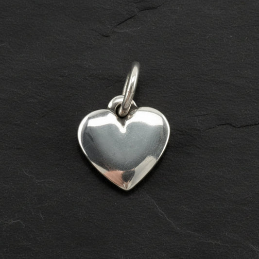 Silver james avery heart-shaped pendant on a dark slate surface