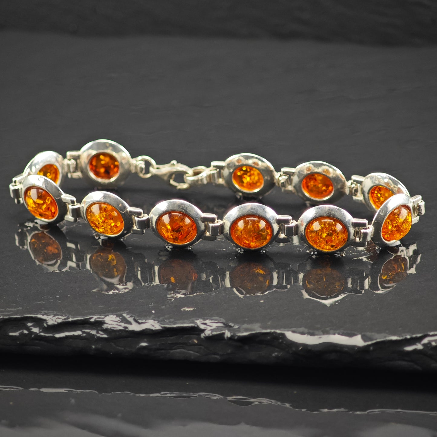 Sterling Silver bracelet with natural Amber gemstones on a dark surface