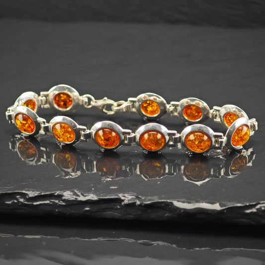 Sterling Silver bracelet with natural Amber gemstones on a dark surface